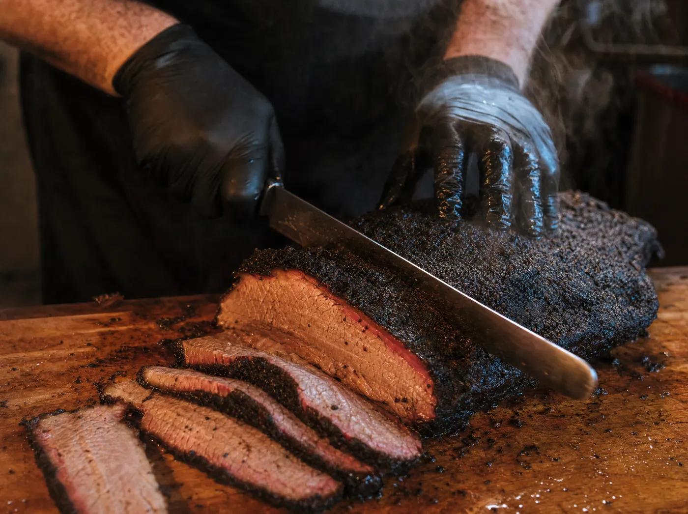 Pitmaster slicing smoked brisket to order at One's BBQ